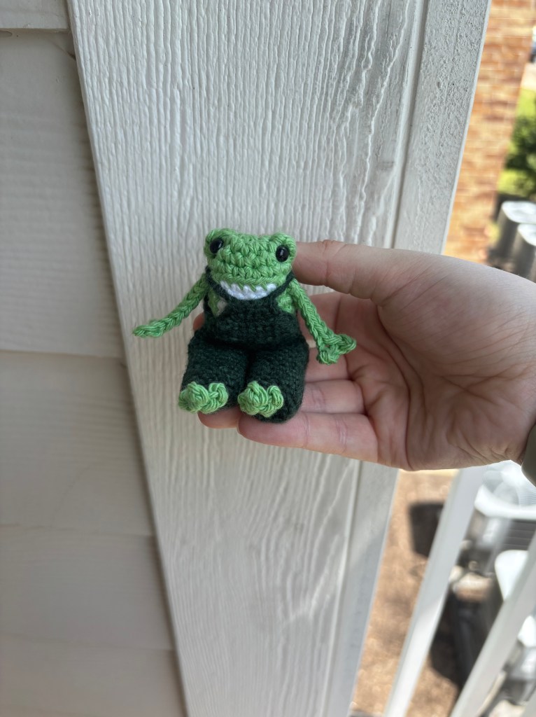 crochet long legged frog in overalls amigurumi sitting