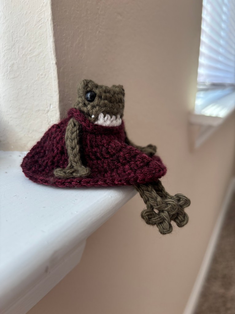 dark green crochet frog in babydoll dress plushie sitting